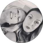 Black and white photo of two smiling women posing closely together, one with blonde hair and the other with dark hair, possibly for a Reviews blog post.